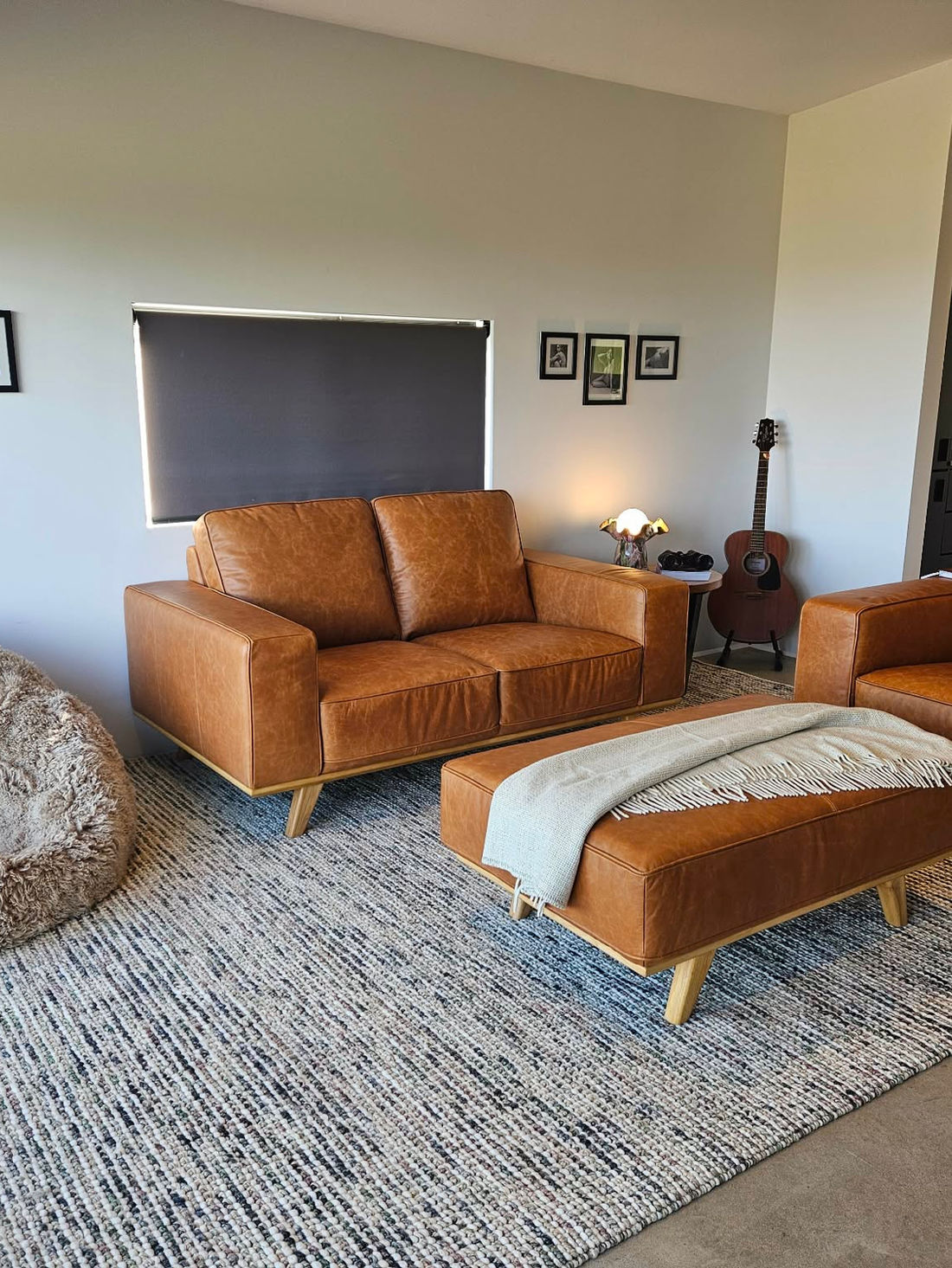 Tan leather armchair with a throw by the window